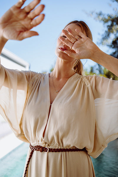 Fashionable woman blocking her face with her hands outdoors