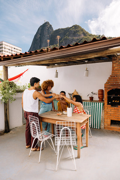 Group of friends enjoying a gathering by a rooftop barbecue area