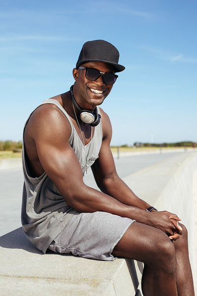 Happy young african man sitting on a promenade
