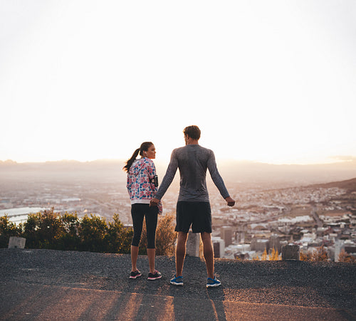 Joggers standing on hillside in morning