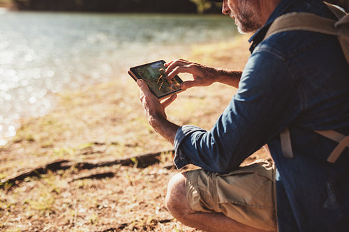 Mature man on hike using a tab for navigation