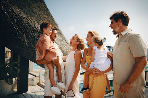 Happy family of tourists talking and laughing at a tropical resort during their summer holiday