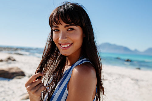 Young female relaxing at the beach and smiling