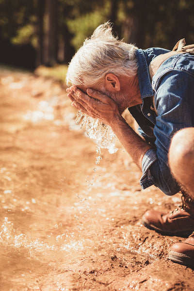 Hiker getting fresh with lake water