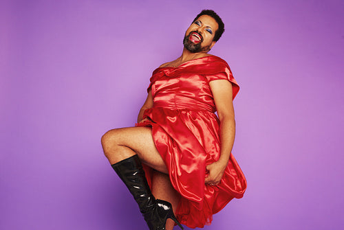 Androgynous male in red shiny dress