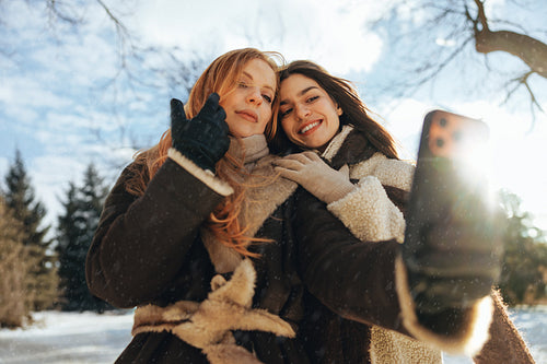 Women take a selfie together outdoors in winter