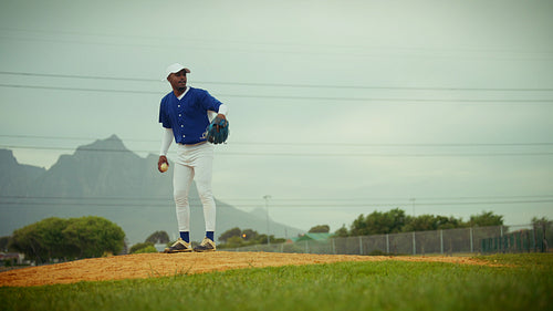 Baseball pitcher on the mound delivers a powerful pitch