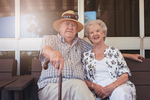 Elderly couple sitting relaxed on a bench outdoors