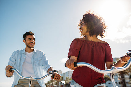 Happy couple riding bicycles in city