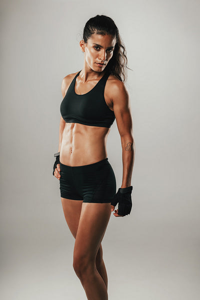 Pretty woman in athletic shorts stares at camera