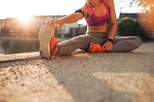 Female athlete stretching legs