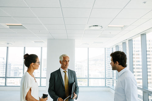 Business people discussing with real estate agent at empty space