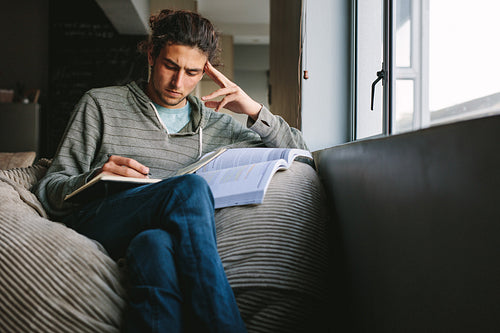 Student studying seriously sitting at home
