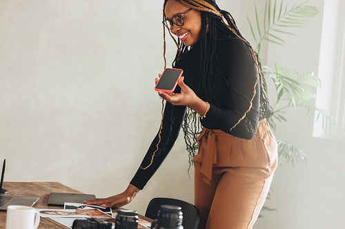 Creative freelancer taking a phone call in her office