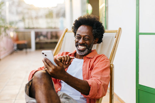 Mature man smiling during an outdoor video call on his smartphone