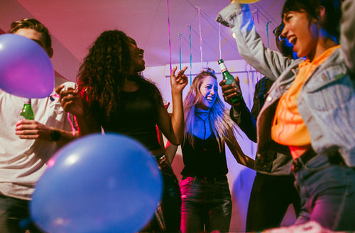 Friends dancing to music with party balloons