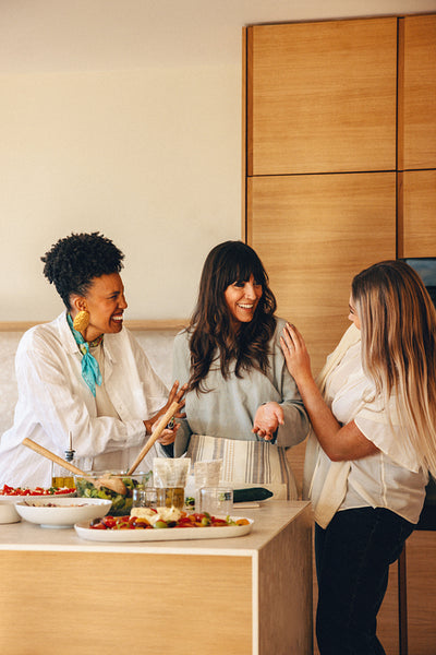 Group of girlfriends preparing a meal together in a kitchen setting