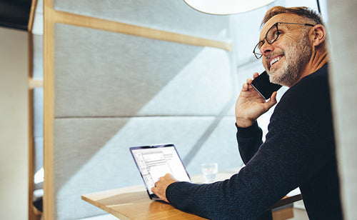 Experienced entrepreneur smiling during a phone call