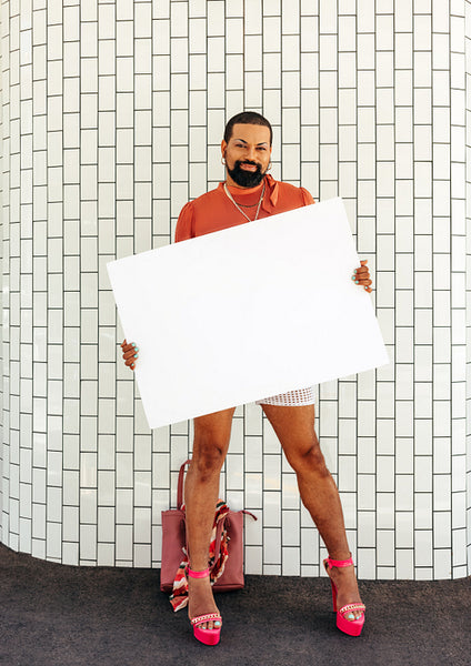 Happy drag queen holding up a banner