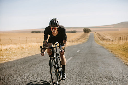 Professional cyclist practising on a long road