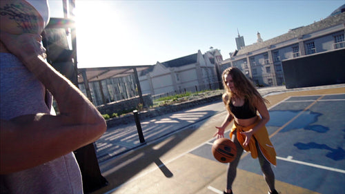 Happy basketball players practicing slam dunking in a basketball court