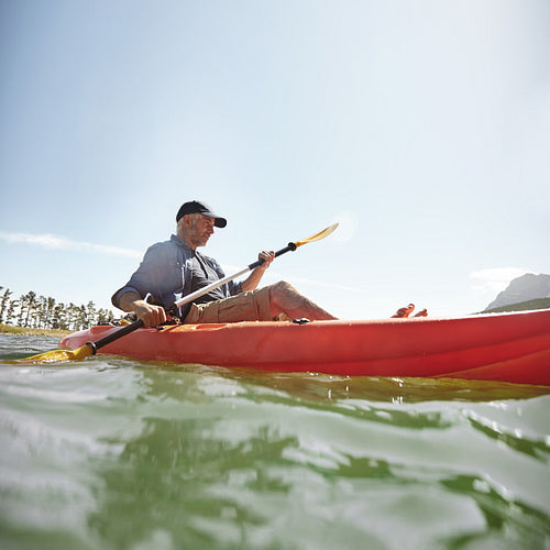 Man kayaking on lake in summer 