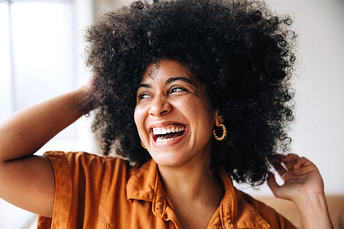 Ethnic businesswoman with Afro hair smiling happily in an office