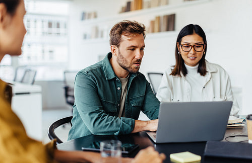 Business man using a laptop in a meeting with his team