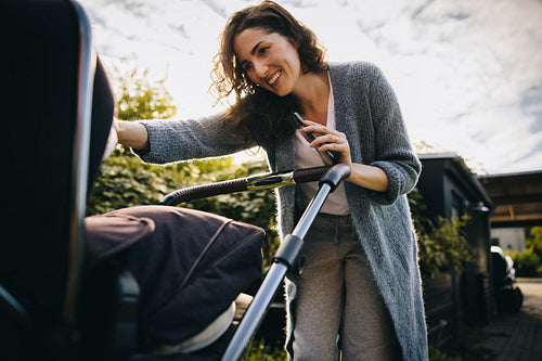 Happy mother with stroller outdoors