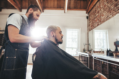 Handsome young man getting haircut