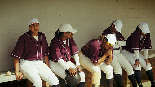 Women's baseball team rests in the dugout