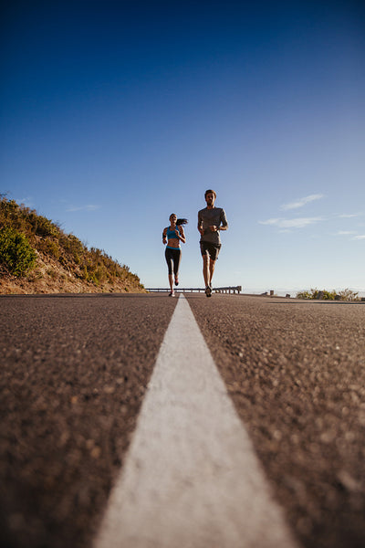 Two young people jogging on the road