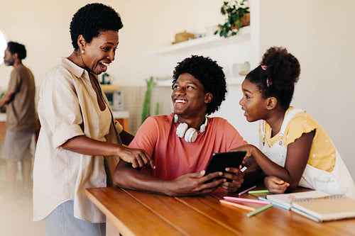 Happy family learning and assisting each other with technology