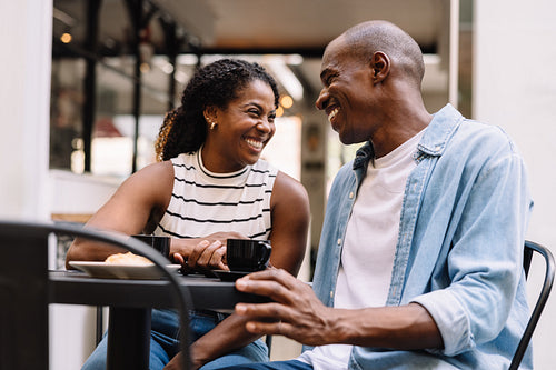 Happy couple enjoying coffee and conversation at a cafe