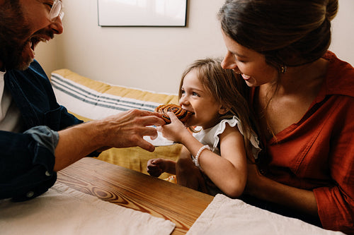 Family shares pastry at home with smiling child