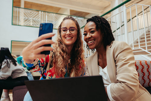 Friendly coworkers taking a selfie together showcasing positive work relationships