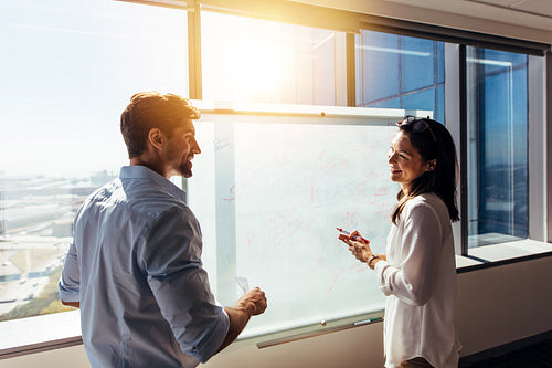 Business investors in boardroom discussing work.