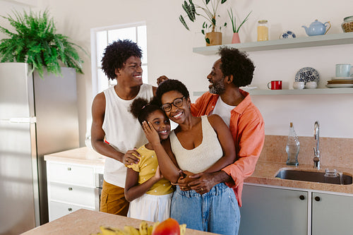 Black family celebrating family day at home, smiling, laughing and spending quality time together