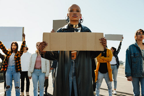 Strong African female activist holding signs outdoors during a peaceful protest