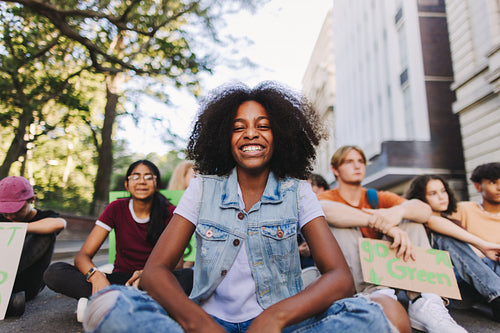 Happy black girl smiling at the camera at a climate protest