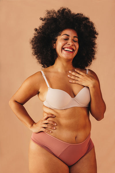 Self-confident young woman smiling happily in a studio