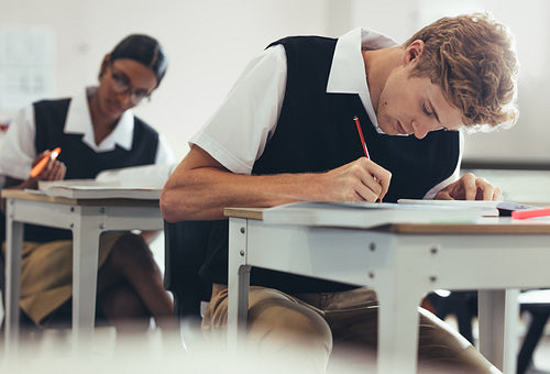 Students concentrating while writing during exam