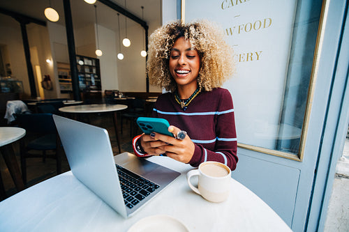 Young business professional in cafe using phone