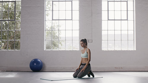 Woman doing elbow plank holds at fitness studio