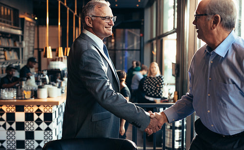 Businessmen handshake in a modern restaurant