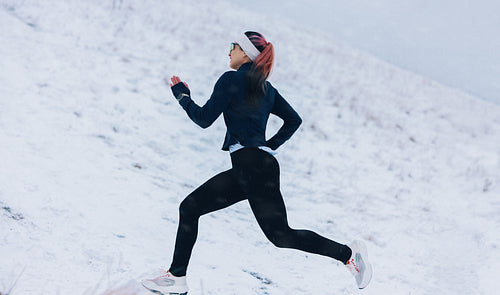 Nature running places the woman on a snowy winter route during fitness training