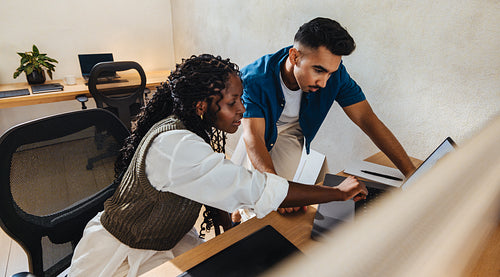 Two young architects collaborating on a project in a modern office space