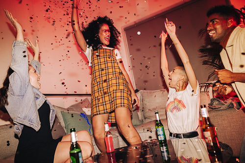 Vibrant friends cheering under falling confetti