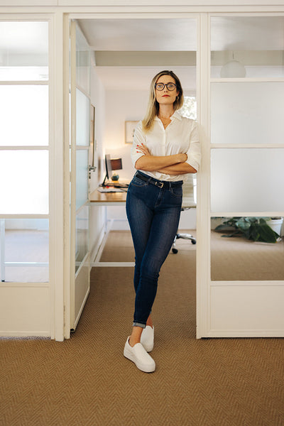 Confident young businesswoman standing in front of her office