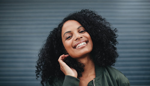 Beautiful african woman standing against gray background